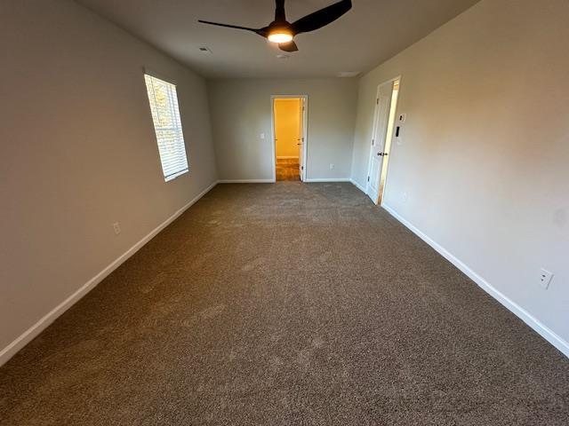 unfurnished room with ceiling fan and carpet