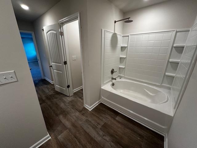 bathroom with hardwood / wood-style flooring and shower / bathtub combination