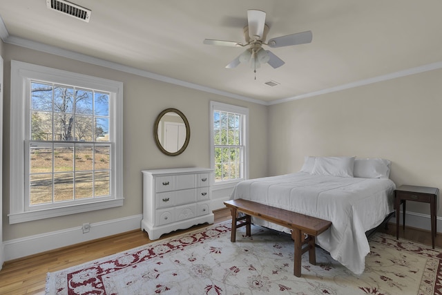 bedroom with light hardwood / wood-style flooring, ornamental molding, and ceiling fan