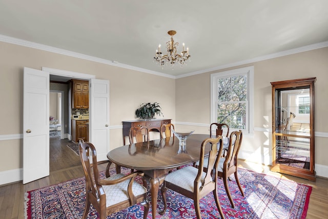 dining room with ornamental molding, dark hardwood / wood-style floors, and a chandelier