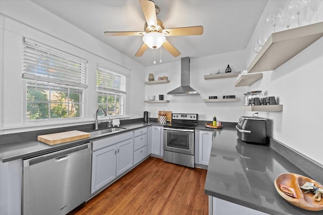 kitchen with wall chimney range hood, sink, gray cabinets, stainless steel appliances, and dark hardwood / wood-style flooring