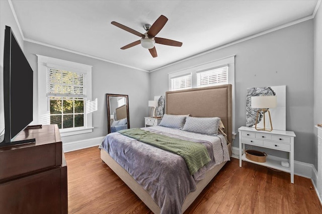 bedroom featuring crown molding, wood-type flooring, and multiple windows