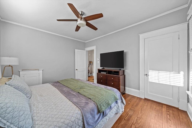 bedroom featuring wood-type flooring, ornamental molding, and ceiling fan