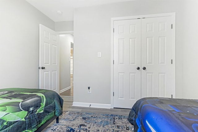 bedroom with dark wood-type flooring and a closet