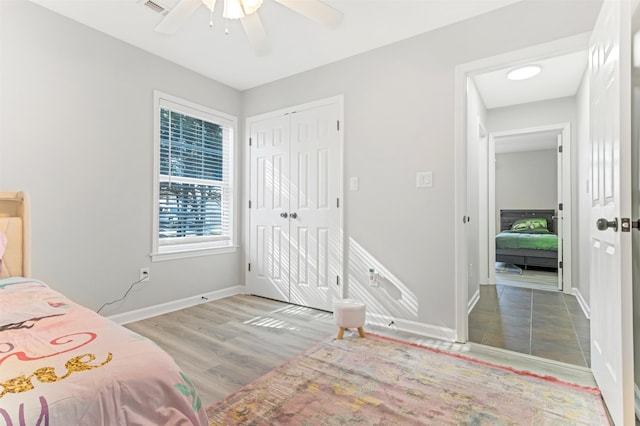 bedroom featuring ceiling fan, light hardwood / wood-style floors, and a closet