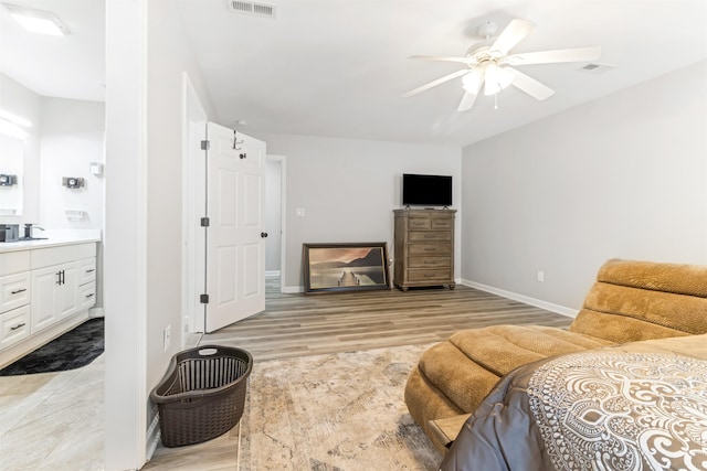 interior space featuring connected bathroom, light hardwood / wood-style flooring, and ceiling fan