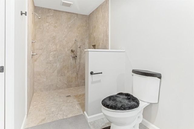 bathroom featuring toilet and a tile shower