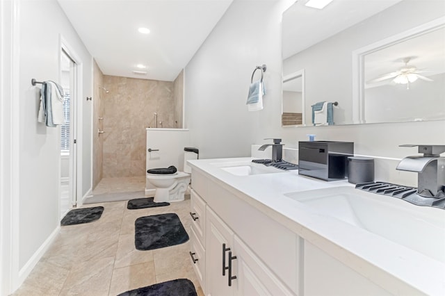 bathroom featuring tiled shower, tile patterned floors, toilet, vanity, and ceiling fan