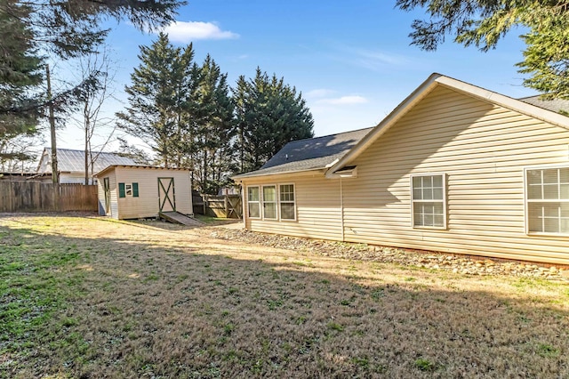 rear view of house featuring a shed and a lawn