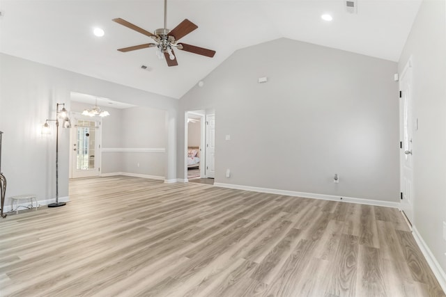 unfurnished living room with ceiling fan with notable chandelier, light hardwood / wood-style flooring, and vaulted ceiling