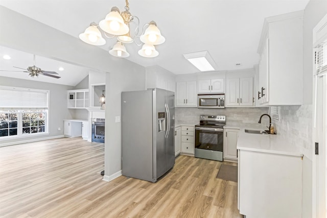 kitchen with sink, white cabinetry, tasteful backsplash, decorative light fixtures, and stainless steel appliances