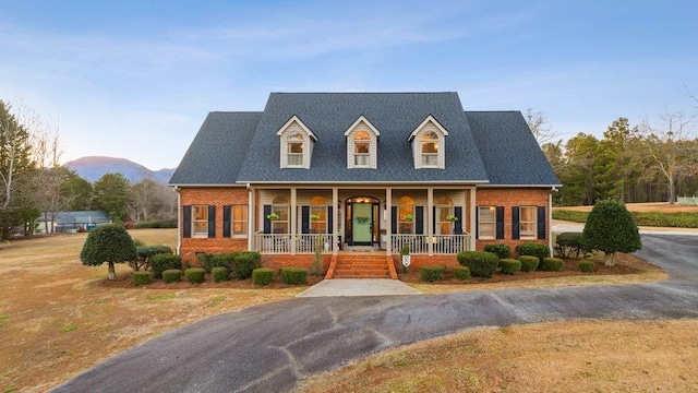 cape cod house featuring a porch