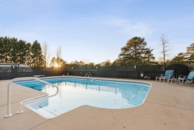 pool at dusk with a patio area