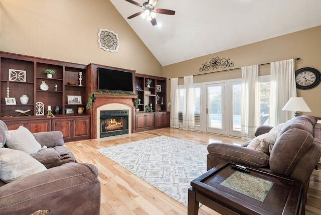 living room featuring hardwood / wood-style flooring, ceiling fan, and high vaulted ceiling