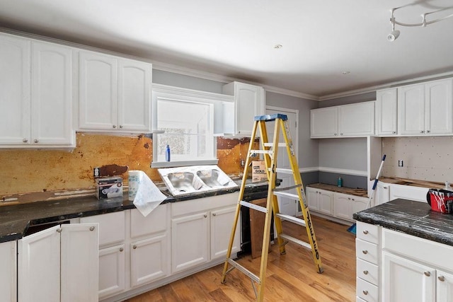 kitchen featuring white cabinetry, crown molding, and light hardwood / wood-style floors