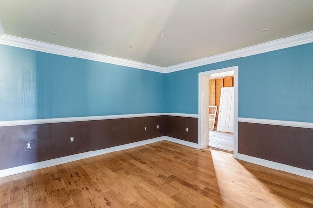 spare room with crown molding and light hardwood / wood-style floors