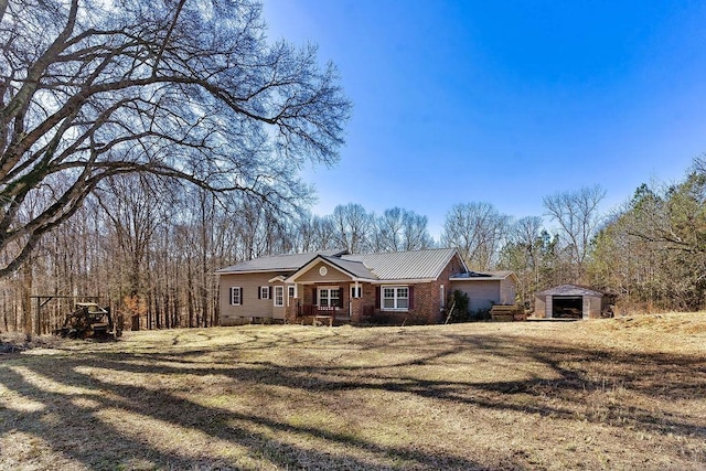 ranch-style house with a storage unit and a front lawn