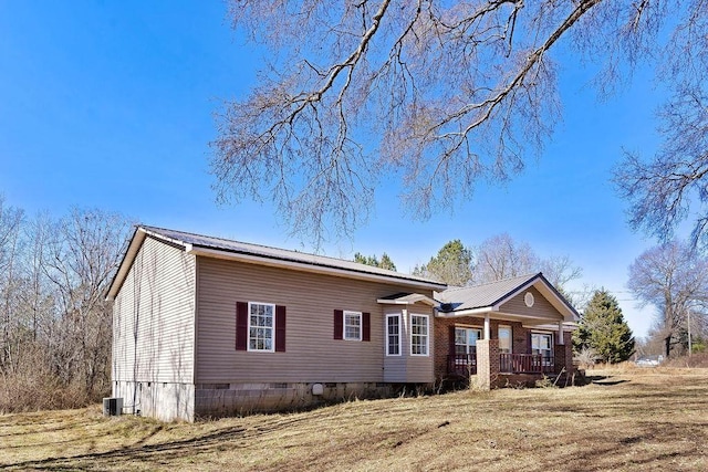 view of front facade with a porch, central AC unit, and a front yard