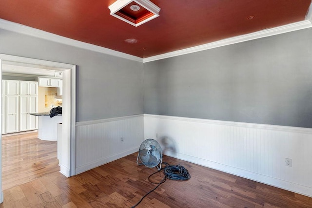 empty room featuring crown molding and light wood-type flooring