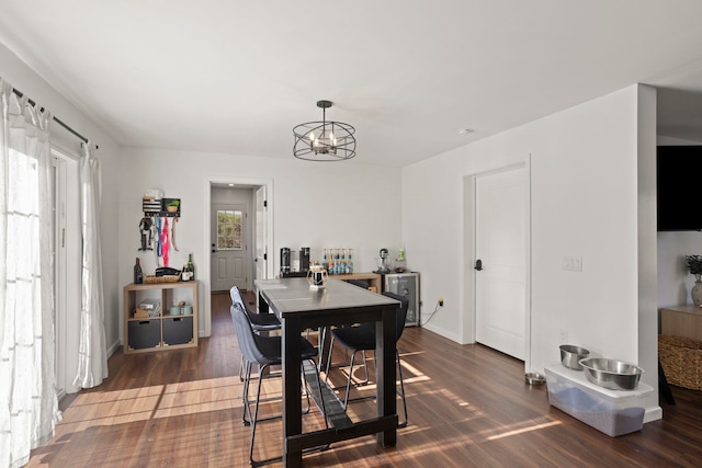 dining room with dark hardwood / wood-style flooring and a notable chandelier