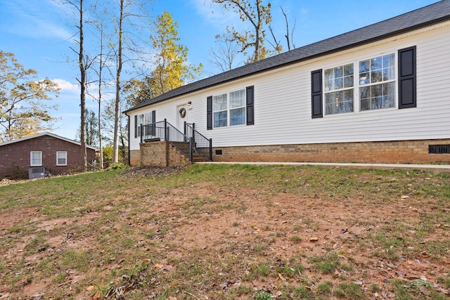 view of front of house featuring cooling unit and a front yard