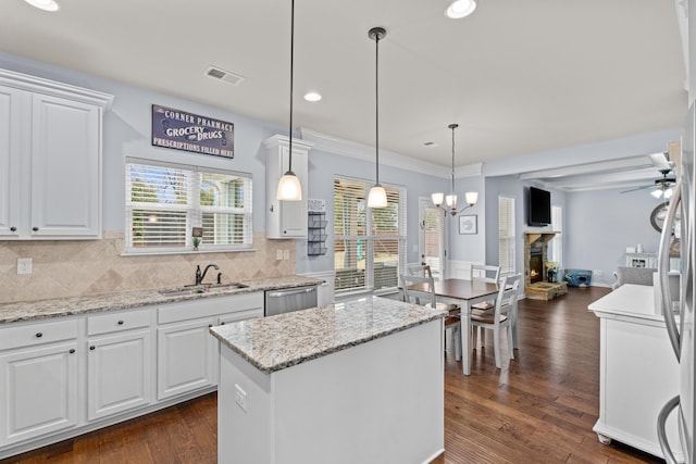 kitchen with white cabinetry, a center island, sink, and decorative light fixtures