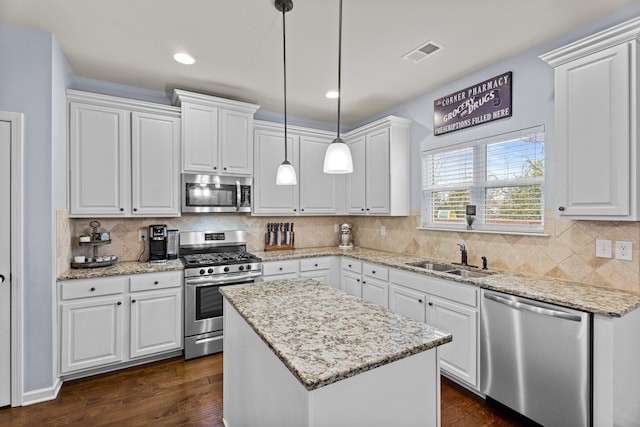 kitchen featuring pendant lighting, white cabinetry, stainless steel appliances, and sink