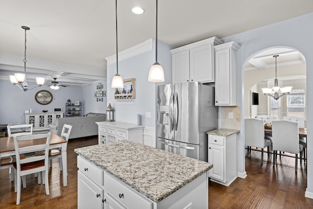 kitchen with pendant lighting, light stone countertops, white cabinets, dark hardwood / wood-style flooring, and stainless steel fridge with ice dispenser