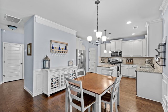 dining room featuring an inviting chandelier, sink, and dark wood-type flooring