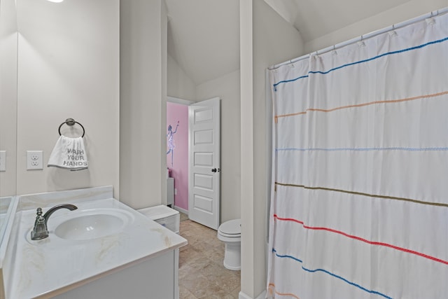 bathroom with vanity, toilet, and vaulted ceiling