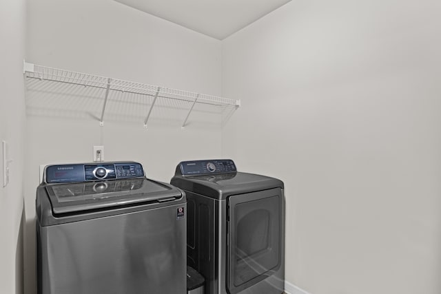 clothes washing area with washing machine and dryer