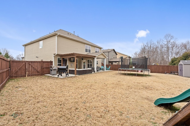 rear view of property with a storage shed, a trampoline, outdoor lounge area, a patio, and a playground