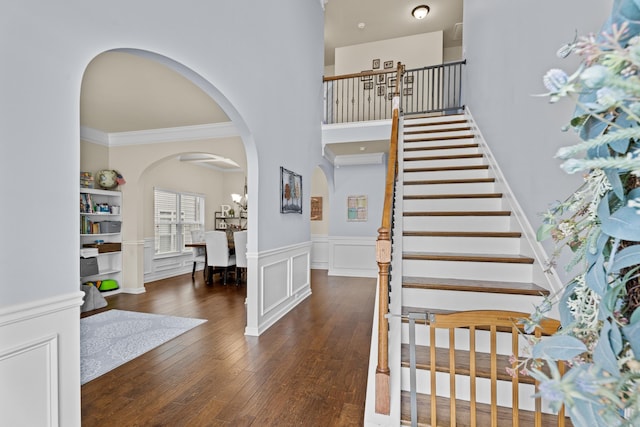 entryway with dark hardwood / wood-style flooring and crown molding