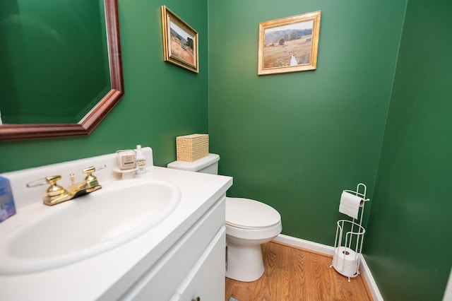 bathroom featuring vanity, wood-type flooring, and toilet