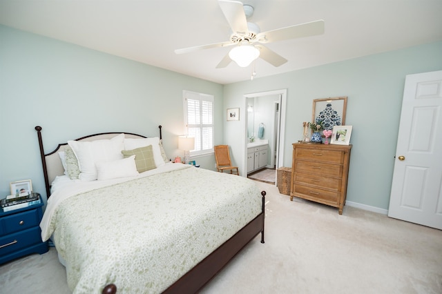 bedroom featuring ensuite bath, light colored carpet, and ceiling fan