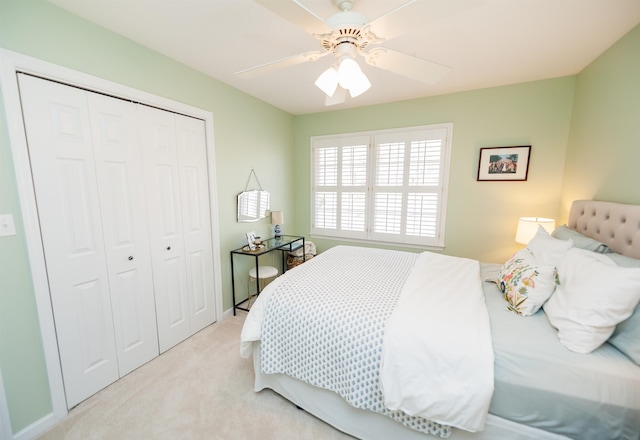 bedroom with light carpet, ceiling fan, and a closet