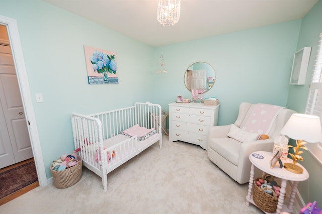 bedroom with an inviting chandelier, light carpet, and a crib