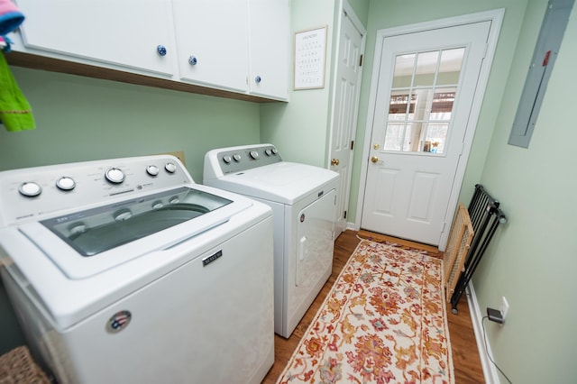 washroom featuring cabinets, washer and clothes dryer, and light hardwood / wood-style flooring