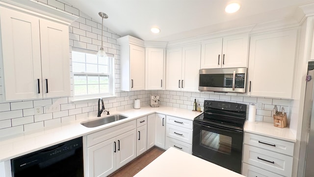 kitchen featuring white cabinetry, sink, pendant lighting, and black appliances