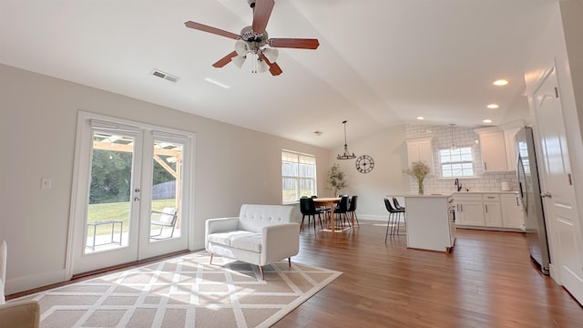 living area with french doors, lofted ceiling, sink, hardwood / wood-style flooring, and ceiling fan