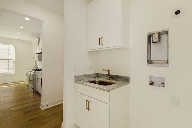 clothes washing area featuring cabinets, washer hookup, dark hardwood / wood-style floors, and sink