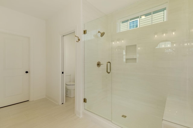 bathroom featuring an enclosed shower and toilet