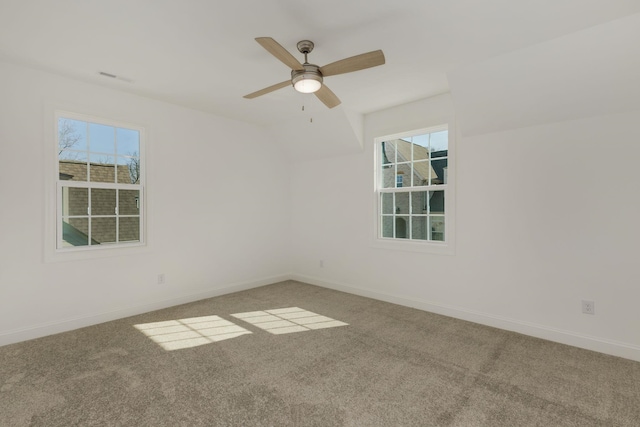 carpeted spare room featuring ceiling fan and a healthy amount of sunlight