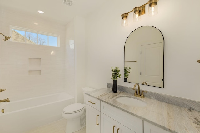 full bathroom featuring tiled shower / bath, vanity, and toilet