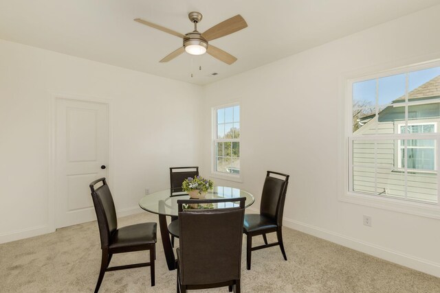 carpeted dining room featuring ceiling fan