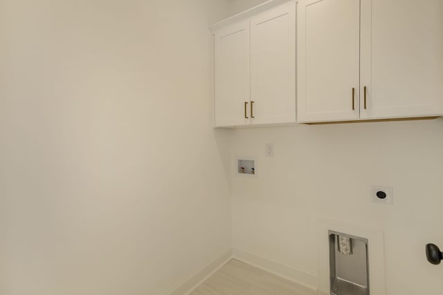 clothes washing area featuring cabinets, hookup for a washing machine, and electric dryer hookup