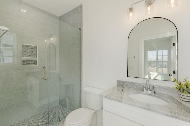 bathroom featuring walk in shower, vanity, and toilet