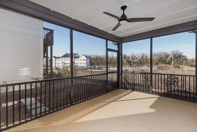 unfurnished sunroom featuring ceiling fan and a wealth of natural light