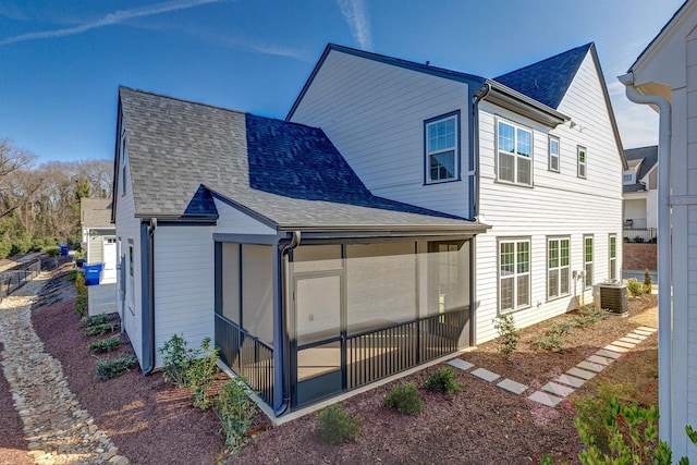 rear view of house featuring a sunroom and central air condition unit