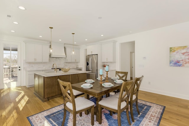 dining area featuring sink and light wood-type flooring